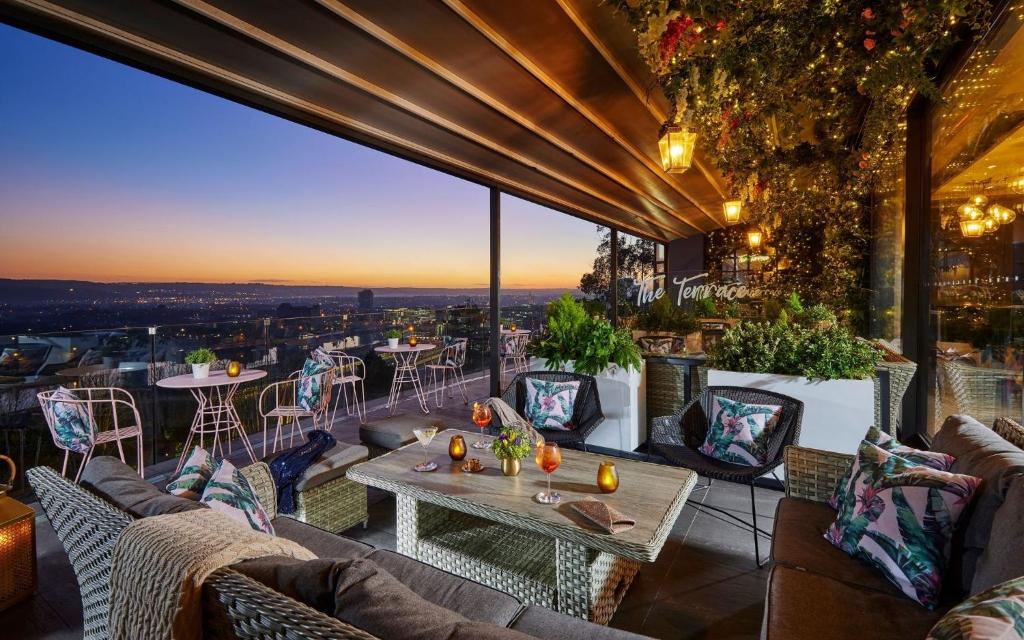 a patio with couches and tables and a view of the city at The Montenotte Hotel in Cork