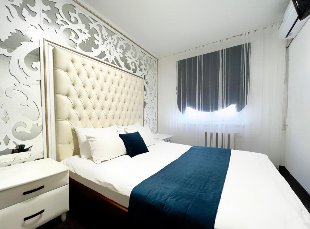 sypialnia z dużym łóżkiem z dużym zagłówkiem w obiekcie Enrico w mieście Dniepr