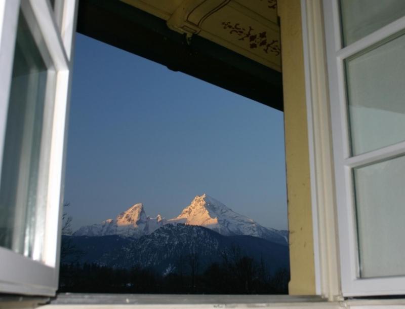 Blick auf einen Berg durch ein Fenster in der Unterkunft Königliche Villa - Turmappartement in Berchtesgaden