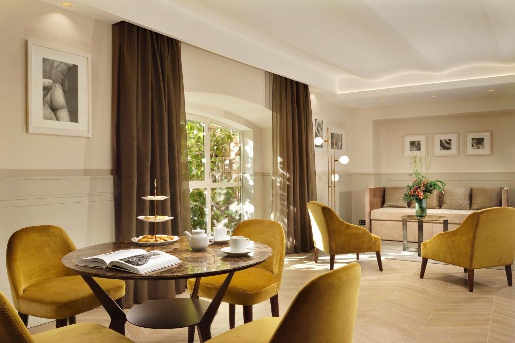 uma sala de estar com mesa e cadeiras em Margutta 54 Luxury Suites em Roma