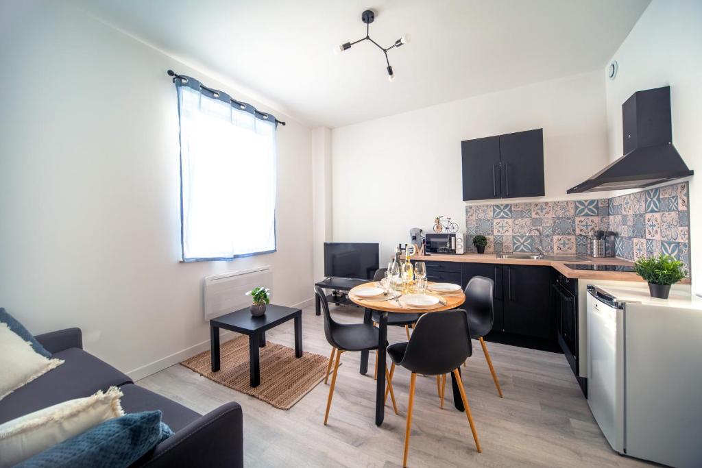 a kitchen and living room with a table and chairs at Appartement Cosy Bressan in Bourg-en-Bresse