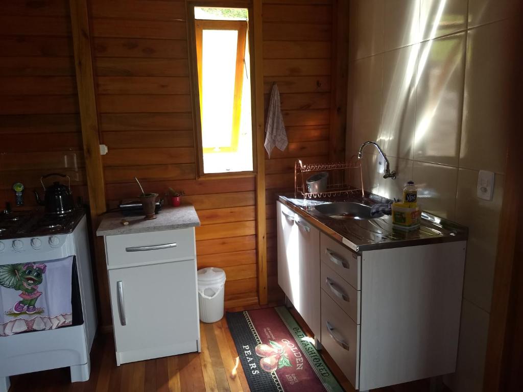 una piccola cucina con lavandino e piano cottura di Chalé Recanto da Tiriva a Urubici