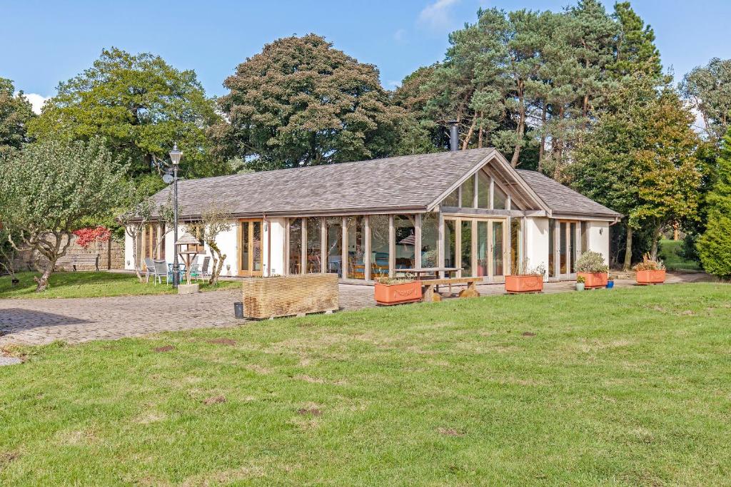 a large building with a grass field in front of it at Amber Lodge in Ashover