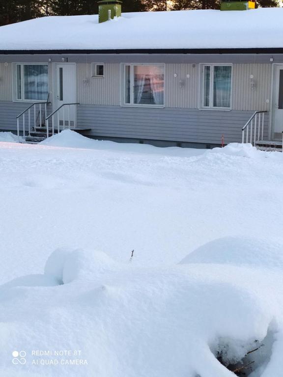 a pile of snow in front of a house at Korento in Sotkajärvi