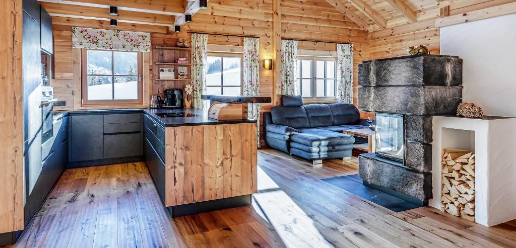 a kitchen and living room with a fireplace in a log cabin at Köck-Chalet in Kleinsölk