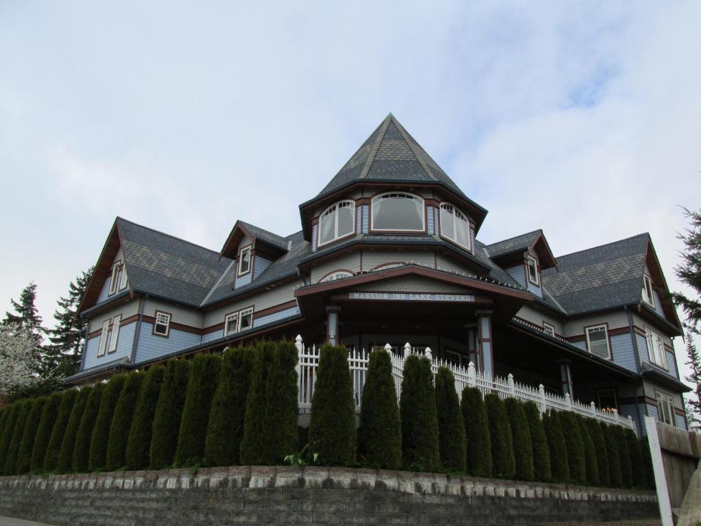 a large house with a fence in front of it at Mansion Inn Lake Stevens in Lake Stevens