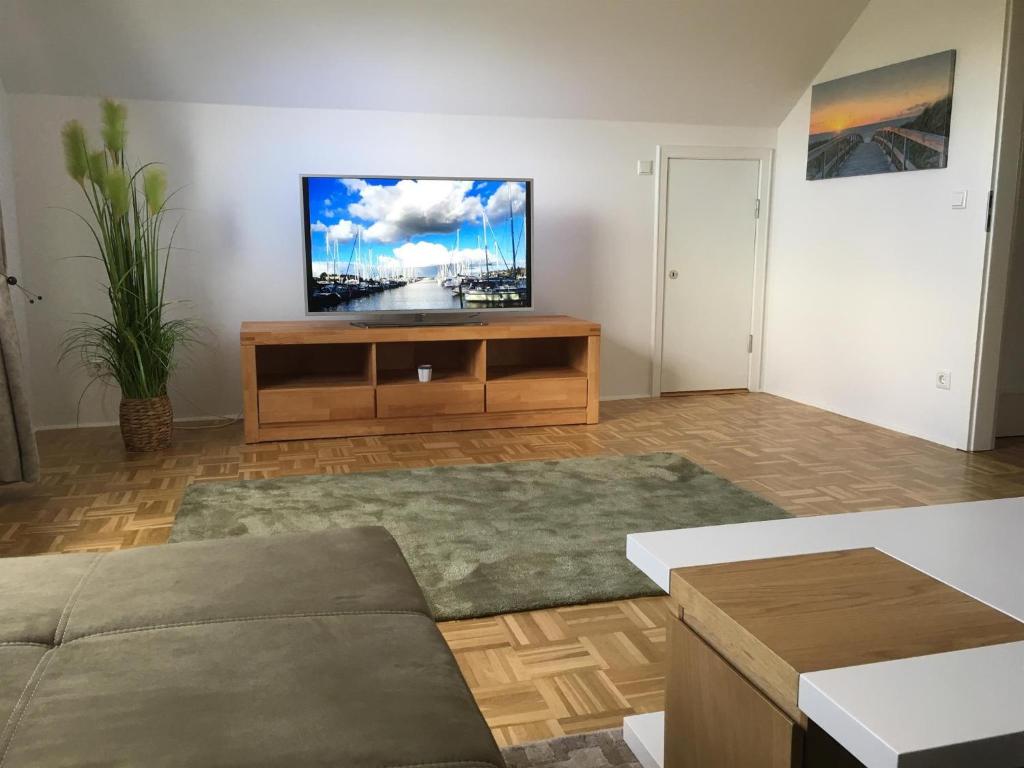 a living room with a flat screen tv on a wall at Ferienwohnung Koje in Wees