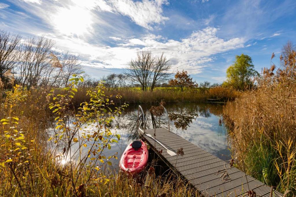 a red boat sitting next to a dock on a lake at Ferienhaus Beim Viechdoktor in Crailsheim