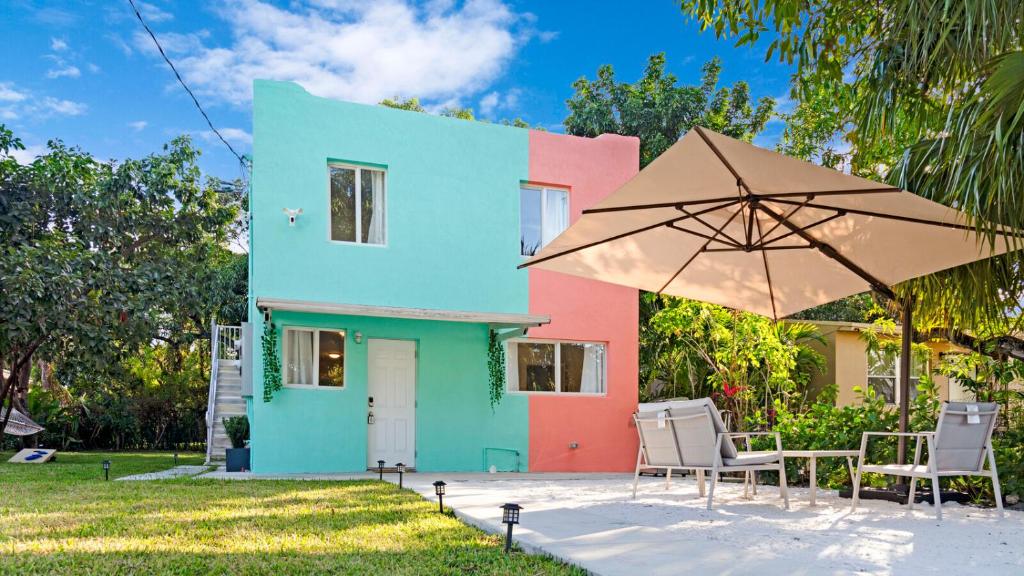 Casa colorida con sillas y sombrilla en Wynwood's Urban Oasis, en Miami