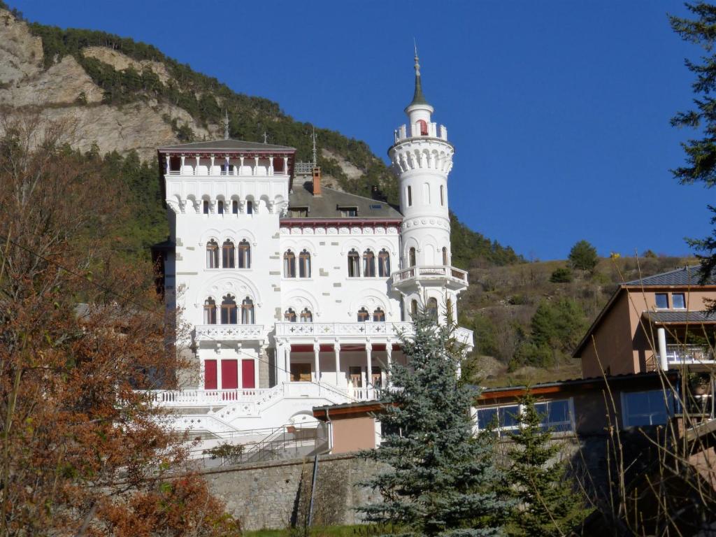 duży biały budynek na szczycie góry w obiekcie Appartement Standing Château des Magnans w mieście Jausiers