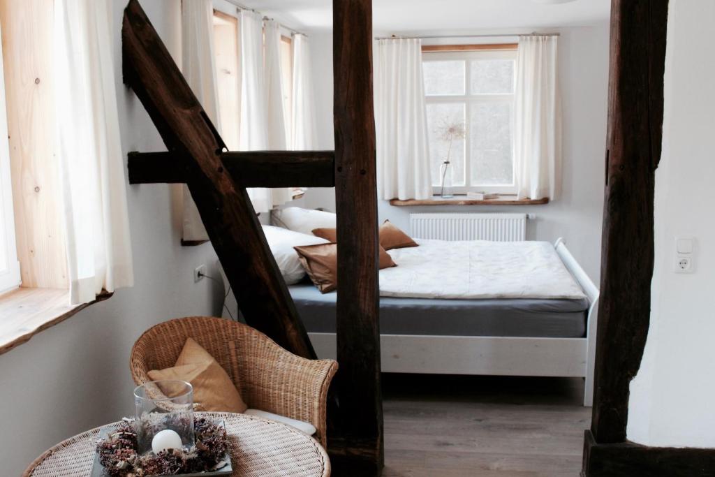 a bedroom with two bunk beds and a chair at Landhaus Weserbergland - Anton in Vahlbruch