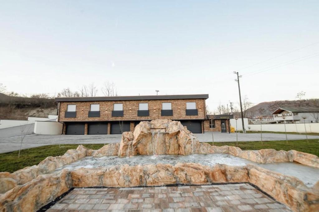 a large stone fountain in front of a building at Zlatna Nit in Novi Pazar