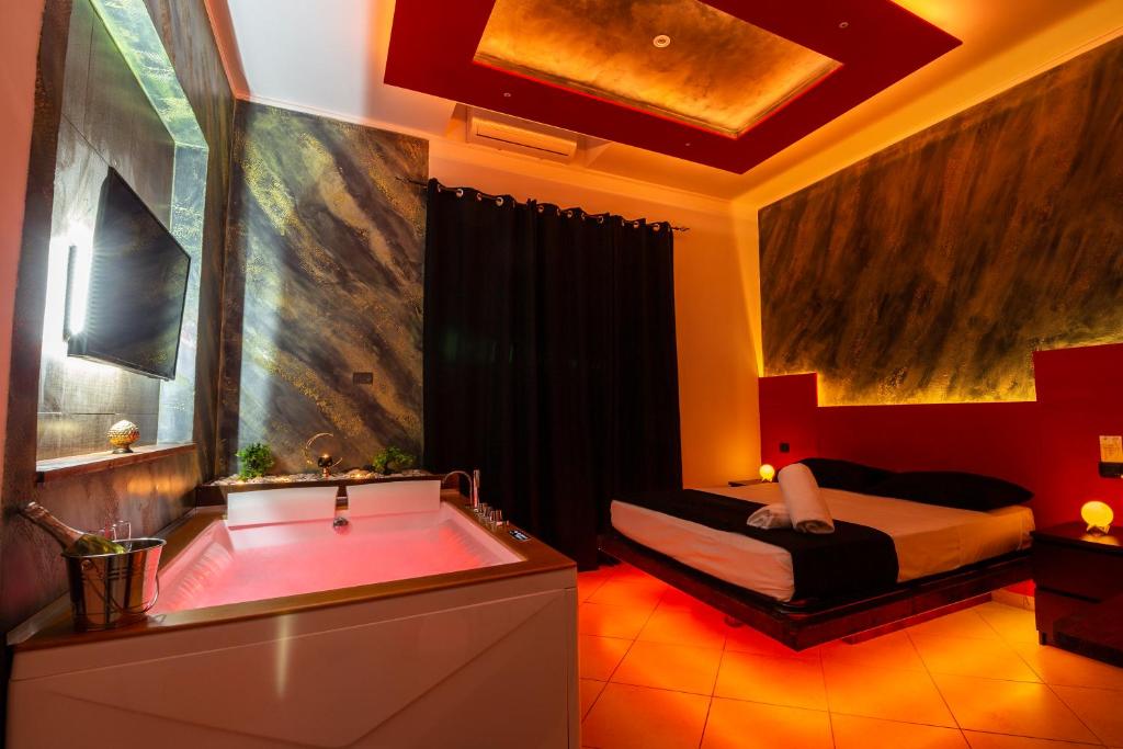 ein Badezimmer mit einer Badewanne, einem Bett und einer Badewanne in der Unterkunft Pompei Luxury Rooms in Pompei