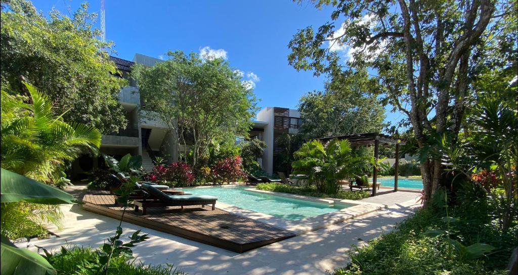 a swimming pool in front of a building at Panacea Condo Tulum in Tulum