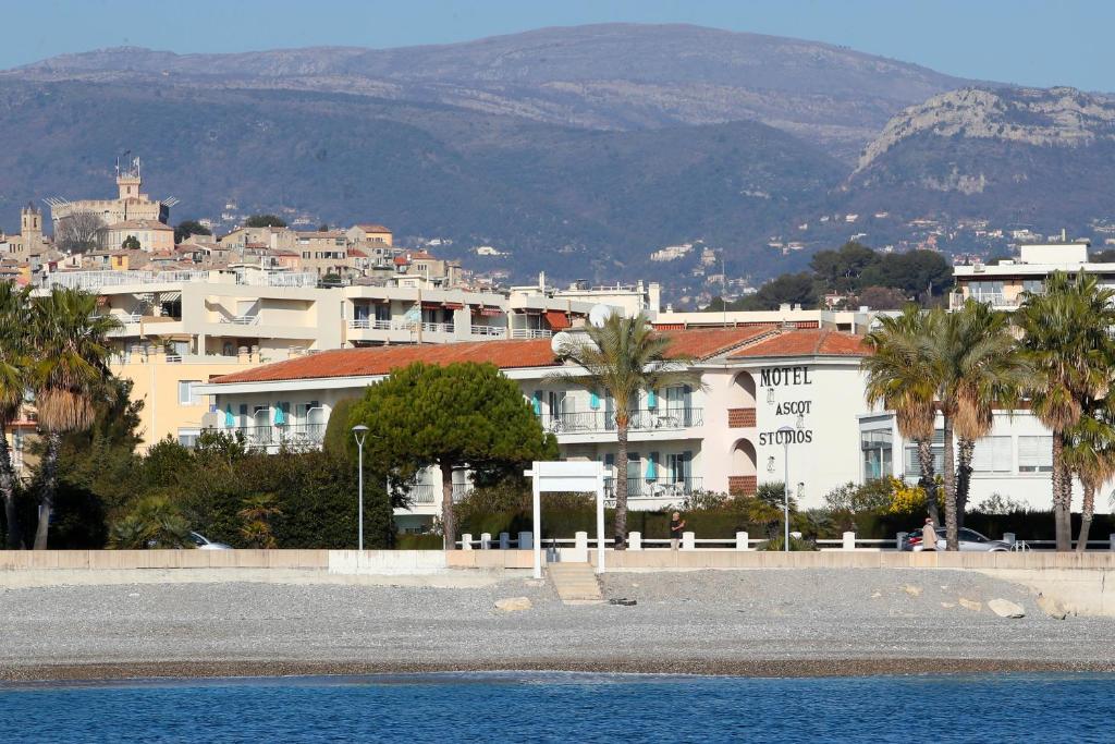 une ville avec des bâtiments, des palmiers et des montagnes dans l'établissement MOTEL ASCOT - Hotel & Appartements, à Cagnes-sur-Mer