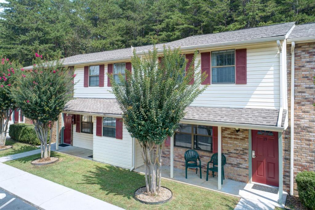 a house with a red door and two trees at Mountain Meadows by Exploria Resorts in Pigeon Forge