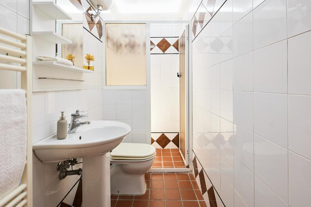 biała łazienka z toaletą i umywalką w obiekcie ✦ GARDEN HOUSE IN CENTRO - FREE PARKING ✦ w mieście Livorno