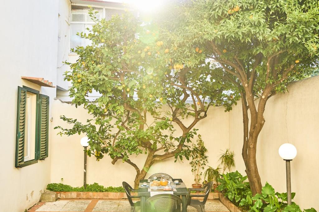 stół i krzesła przed budynkiem z drzewami w obiekcie ✦ GARDEN HOUSE IN CENTRO - FREE PARKING ✦ w mieście Livorno