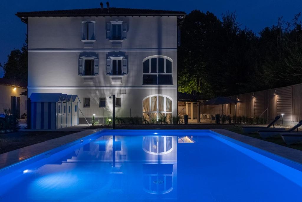 a house with a swimming pool in front of a building at Villa Petra in Novellara