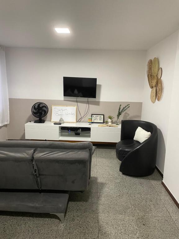 a living room with a couch and a chair at Apartamento quarto e sala próximo ao mar in Maceió