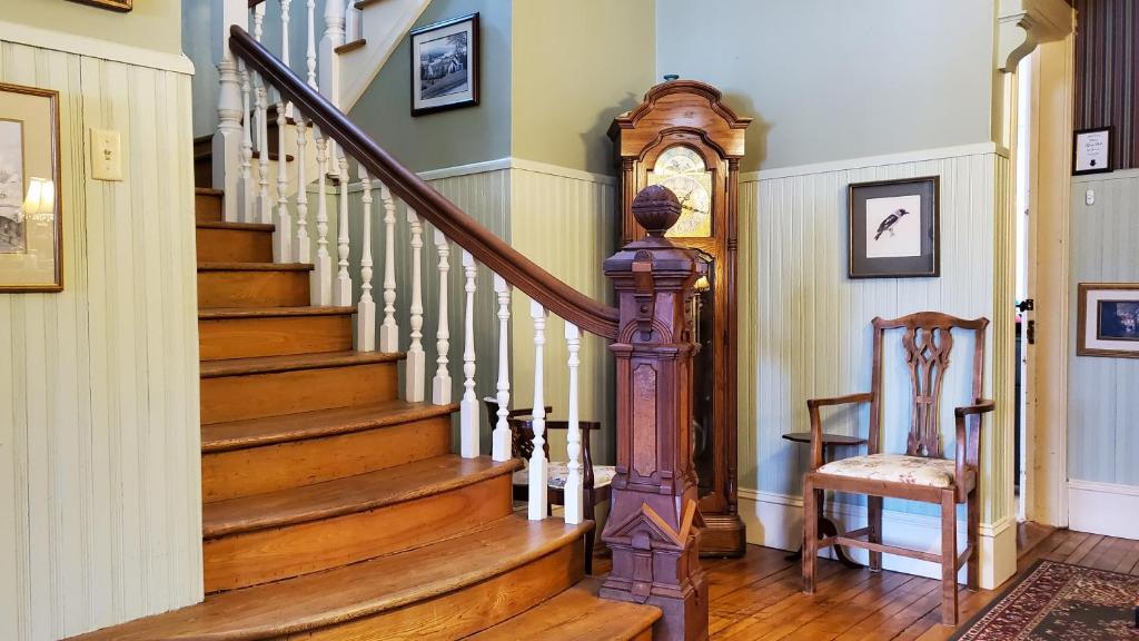 a staircase in a home with a grandfather clock at The Lark & Loon Inn in Annapolis Royal