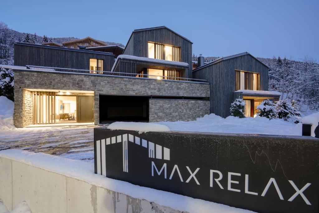 una casa en la nieve con un cartel delante en Max Relax SUMMERCARD INCLUDED Ski in-ski out, en Zell am See