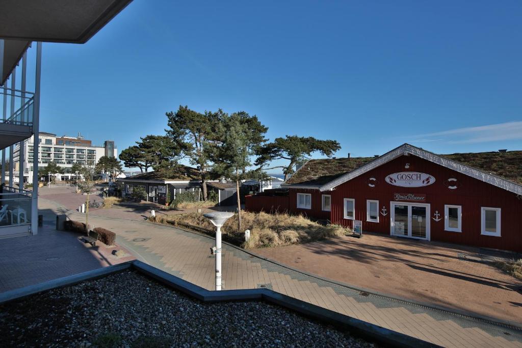 ein rotes Gebäude mit einer Treppe vor einer Straße in der Unterkunft Residenz Ostseestrand Residenz Ostseestrand Appartement 10 in Scharbeutz