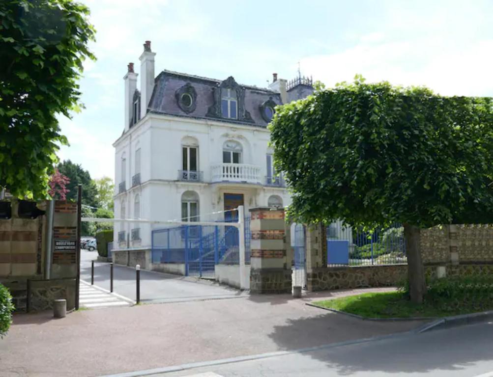 ein altes weißes Haus mit einem Baum davor in der Unterkunft VILLA CAMILLE - Proche Paris & Disneyland in Lagny