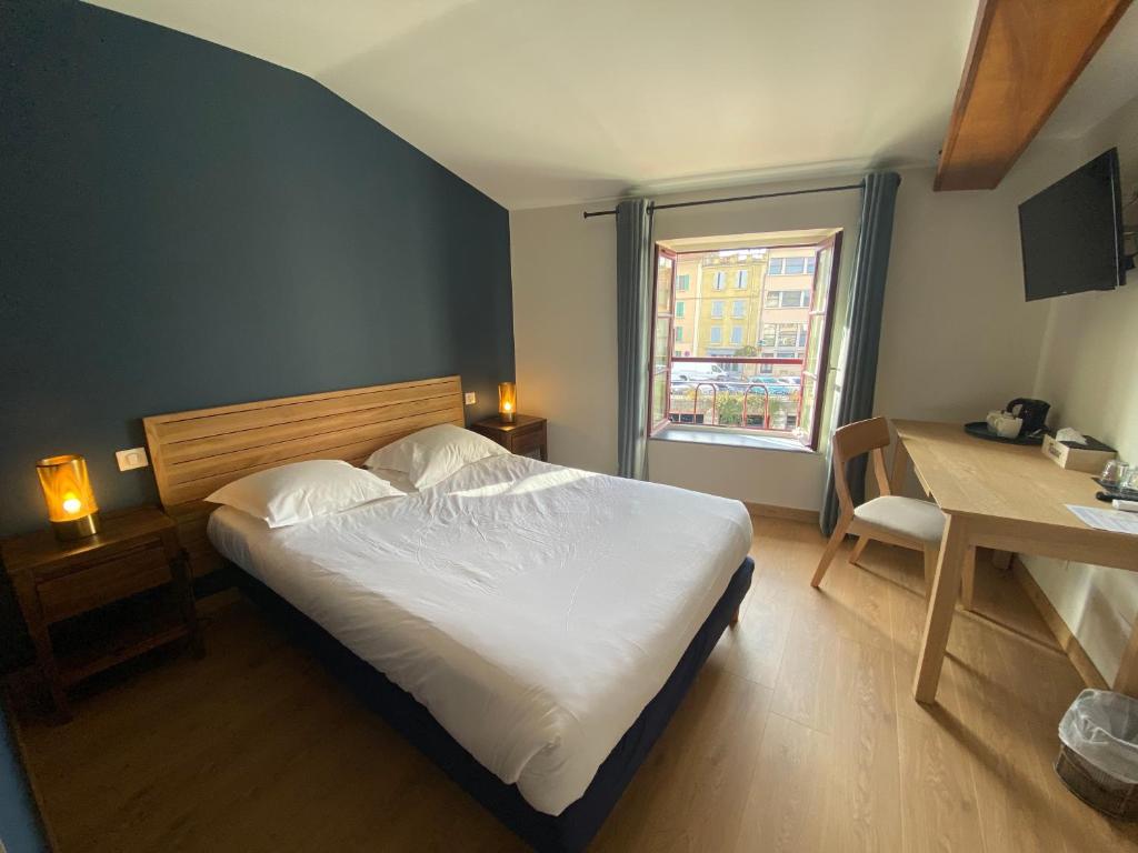 1 dormitorio con cama, escritorio y ventana en Le Miredames Hôtel-Bar en Castres