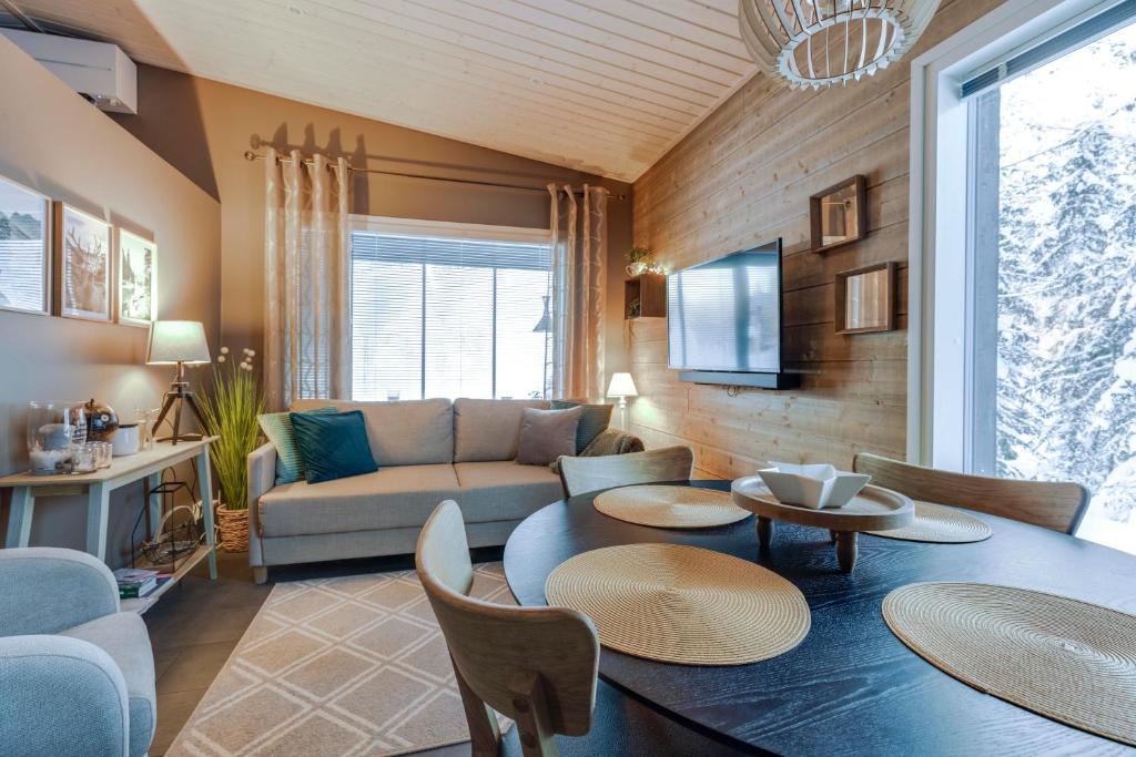 ein Wohnzimmer mit einem Sofa und einem Tisch in der Unterkunft Villa Karhukoto Ruka in Kuusamo