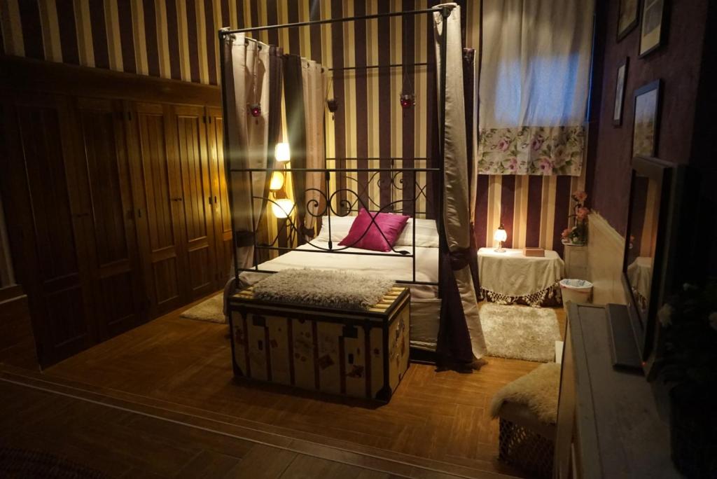 a room with a canopy bed with a bench in it at Lantica roccia in Manzanares el Real
