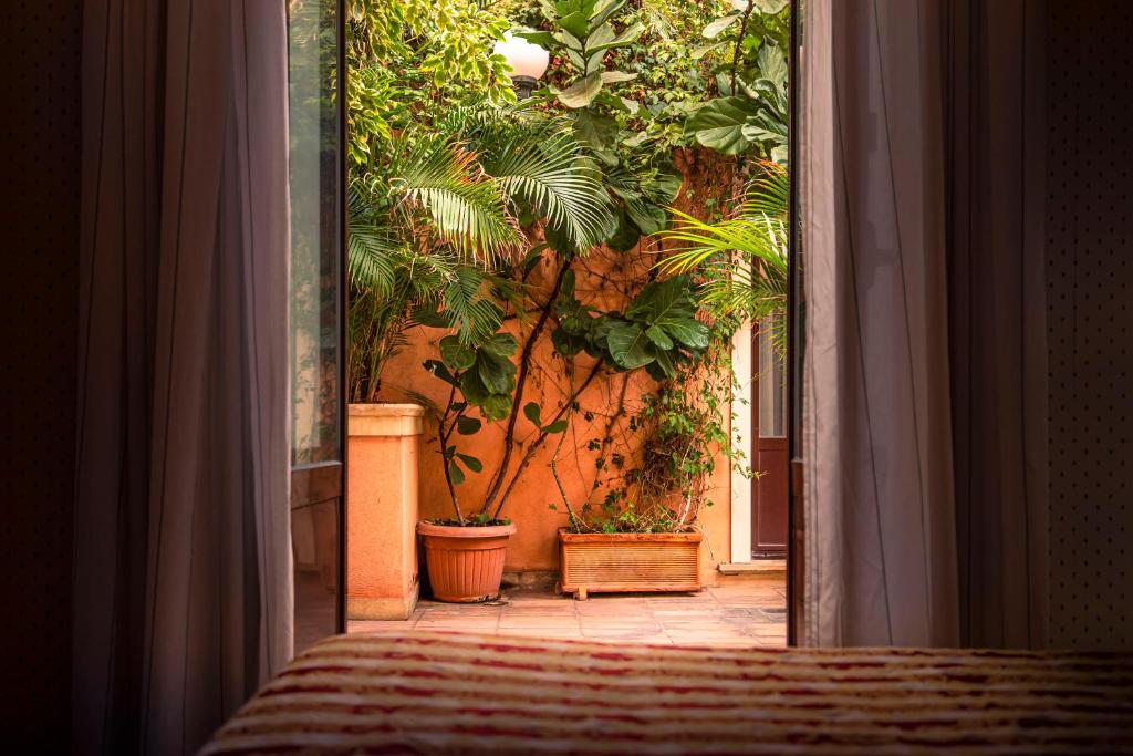 a room with potted plants on a wall at Hotel Villa Romeo in Catania