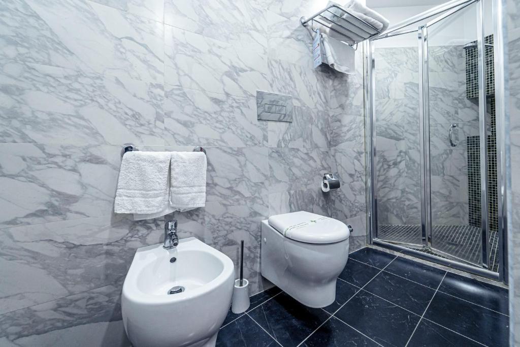 a white bathroom with a toilet and a shower at Hotel Villa Romeo in Catania