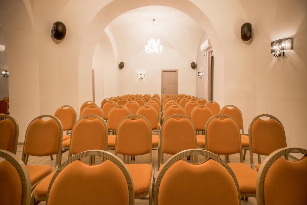 an empty room with orange chairs and an archway at Hotel Villa Romeo in Catania