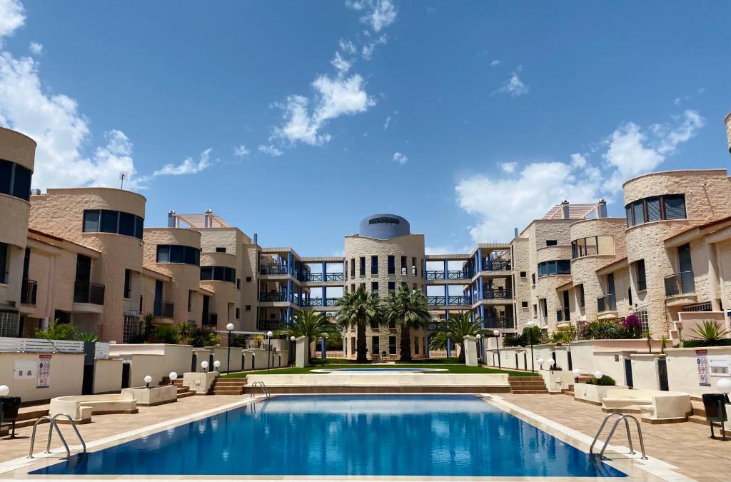 a swimming pool in front of some apartment buildings at Regia Bahia en Cabo Roig in Orihuela Costa