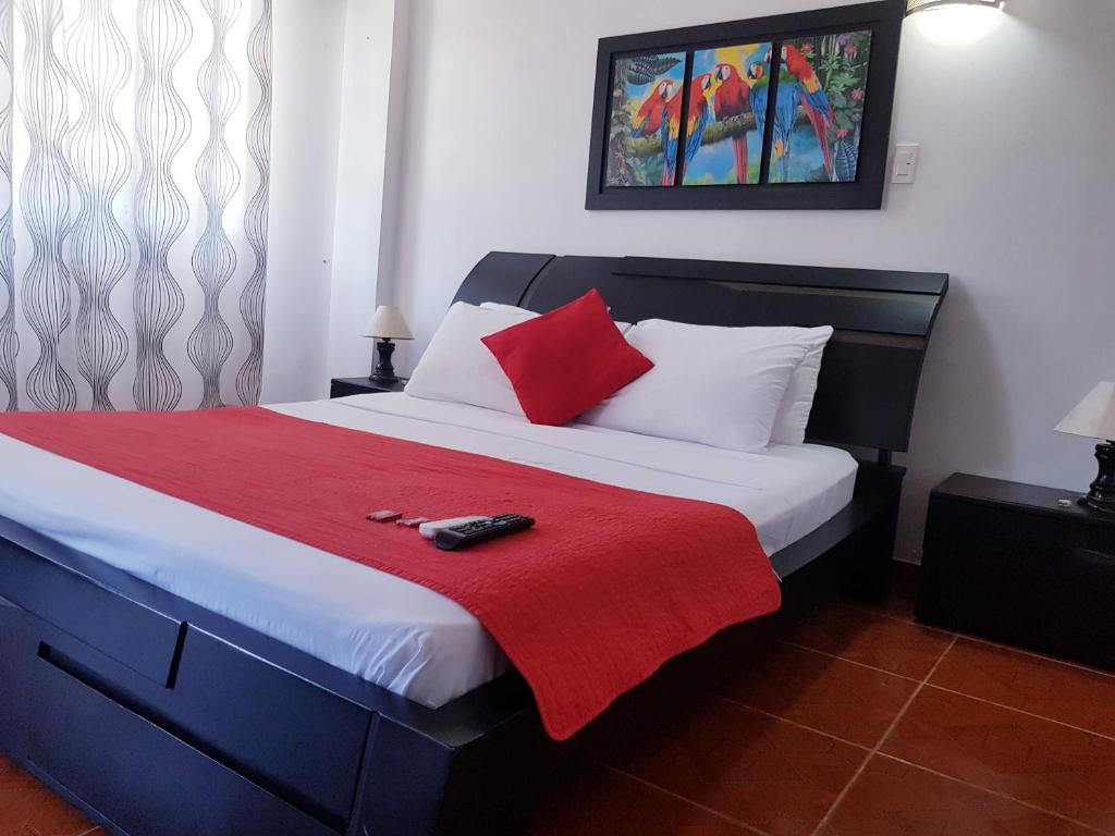 a bedroom with a large bed with a red blanket at Hotel Media Luna in Santa Marta