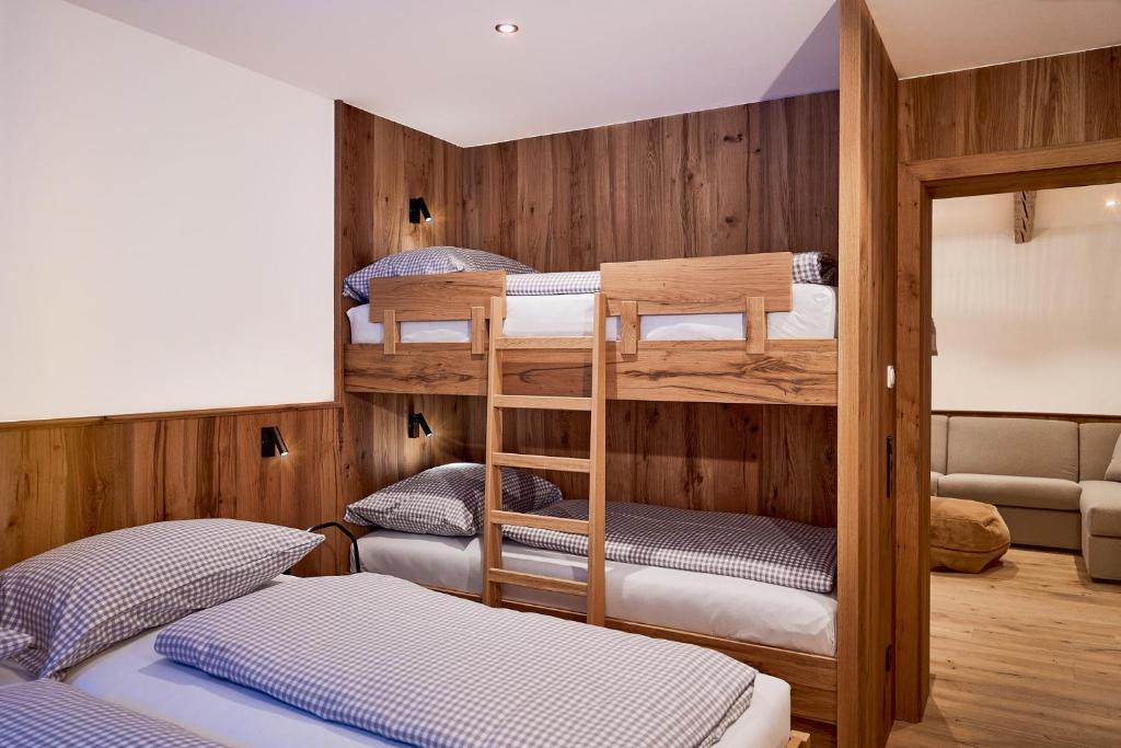 a bunk room with three bunk beds in it at Berghaus Schröcken - Hotel Apartments Spa in Schröcken