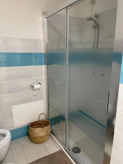 łazienka z prysznicem, toaletą i koszem w obiekcie Zaffiro casa vacanze al mare w mieście Valledoria