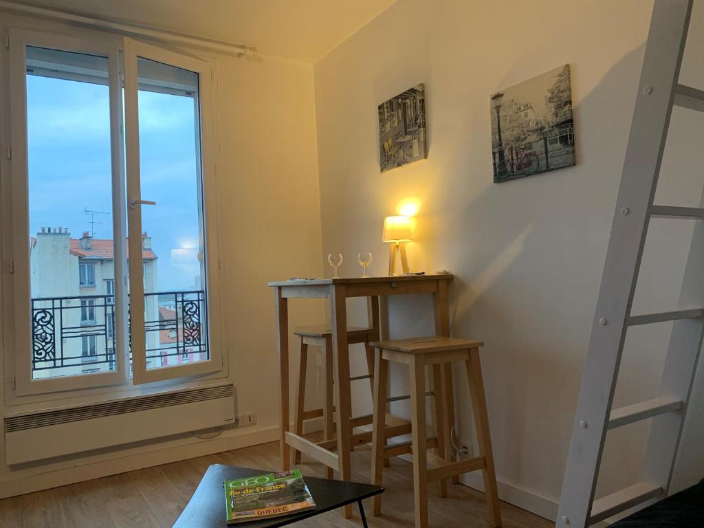 ein Wohnzimmer mit einem Tisch und einem Fenster in der Unterkunft Charmant Studio 3 pers - 20mn Paris - 35mn Disney in Fontenay-sous-Bois