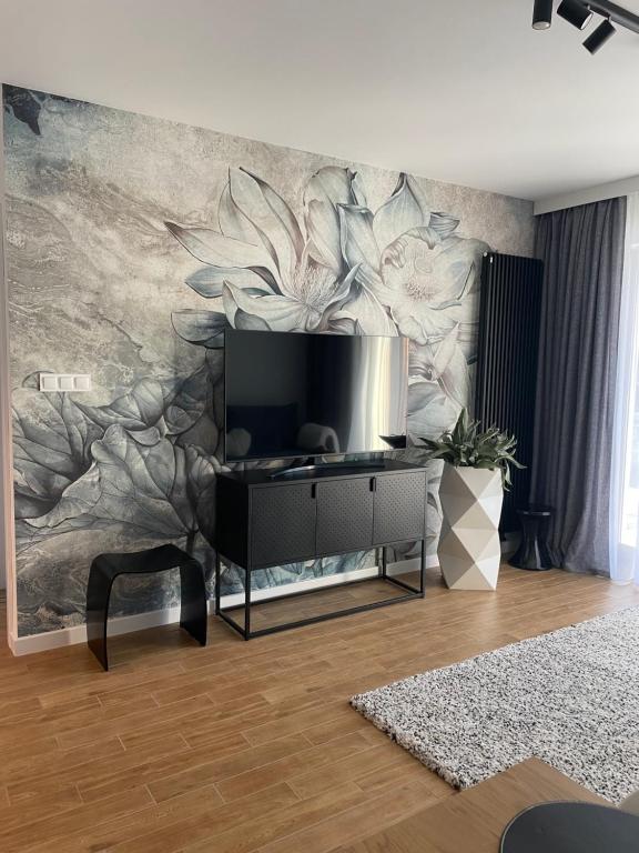 una sala de estar con un mural de flores en la pared en Stone Hill SPA by Clima Apartment, en Szklarska Poręba