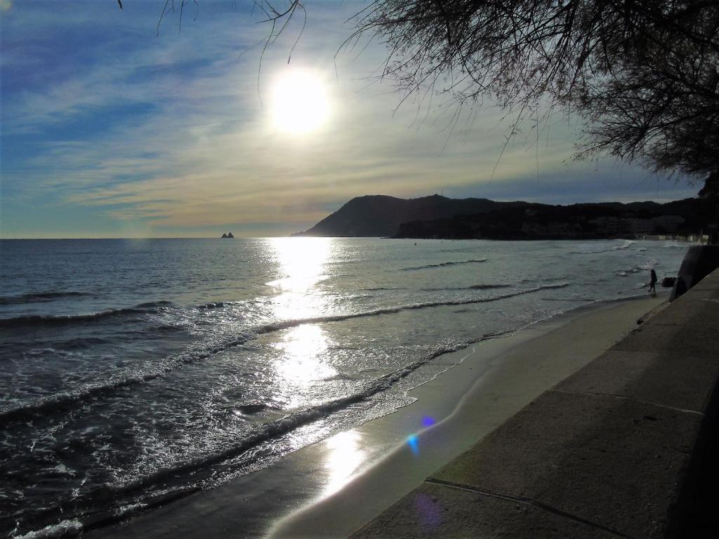 une plage au soleil brillant sur l'eau dans l'établissement cosy studio clim mer 1mn, à La Seyne-sur-Mer