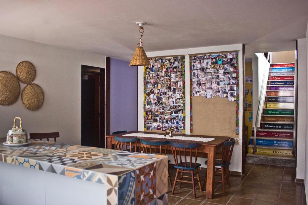 un comedor con una mesa y una pared con fotografías en Slow Hostel - Hospedagem Criativa en João Pessoa