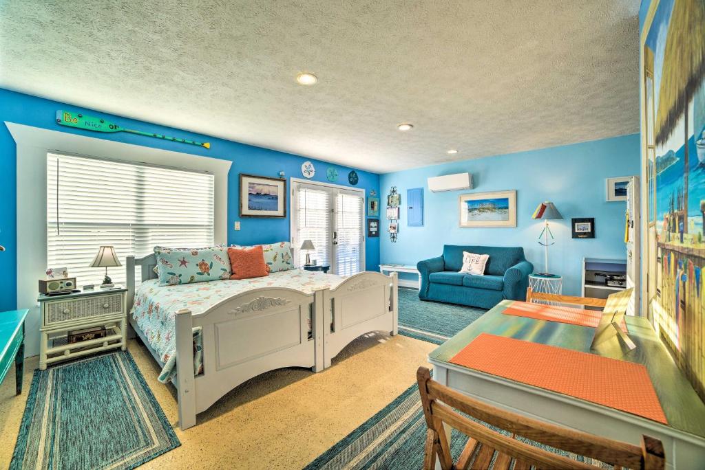 a bedroom with blue walls and a bed and a couch at Studio Steps to Beach and about 7 Miles to Pier Park! in Panama City Beach