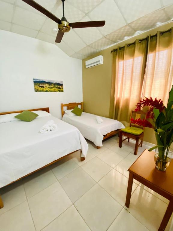 Un dormitorio con dos camas y un ventilador de techo. en Hotel Ana Mary, en Santiago de Veraguas