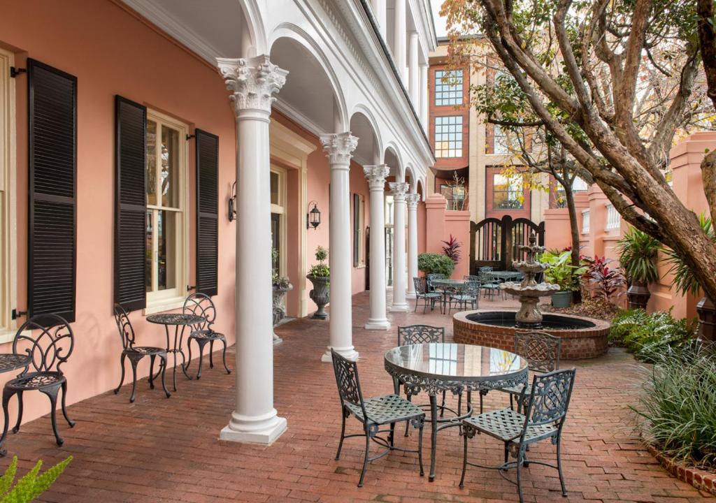 un patio con sillas y mesas y un edificio en Meeting Street Inn, en Charleston