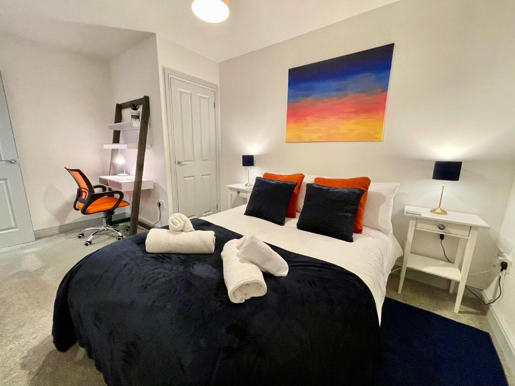 a bedroom with a large bed with towels on it at Bright & Cosy One Bedroom Apartment - Perfect base in Bishop's Stortford in Bishops Stortford