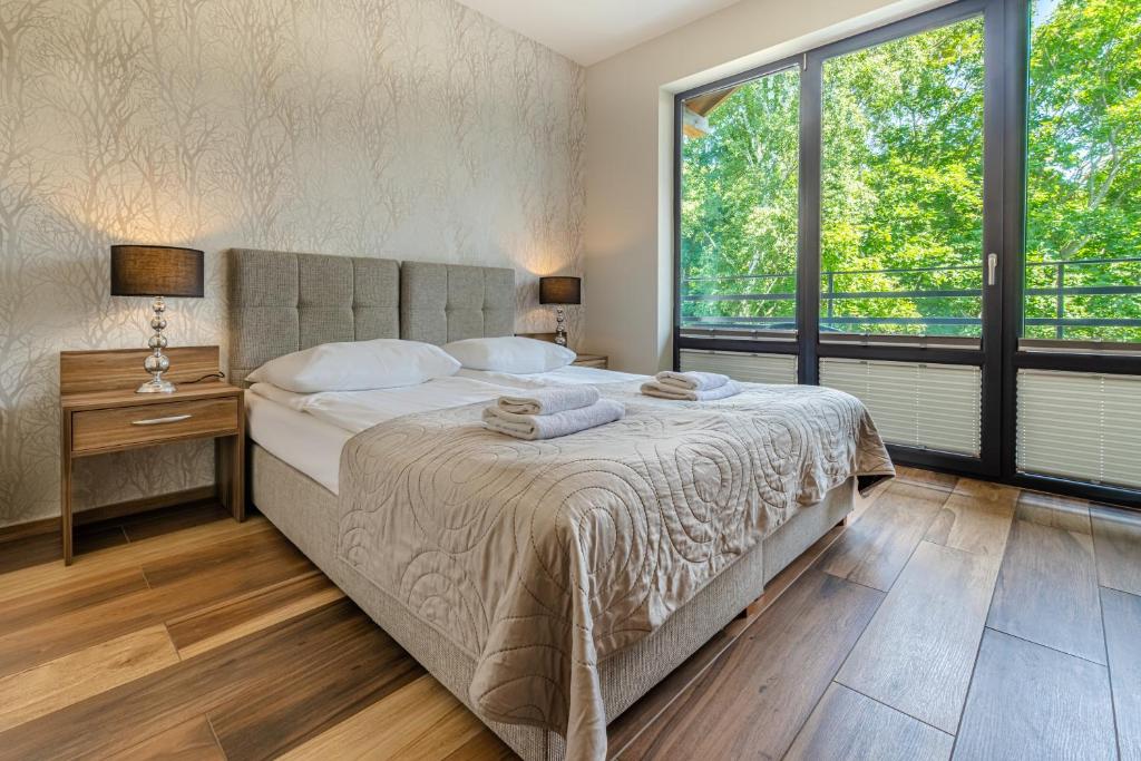 a bedroom with a large bed and a large window at Villa Pacyfic in Krynica Morska