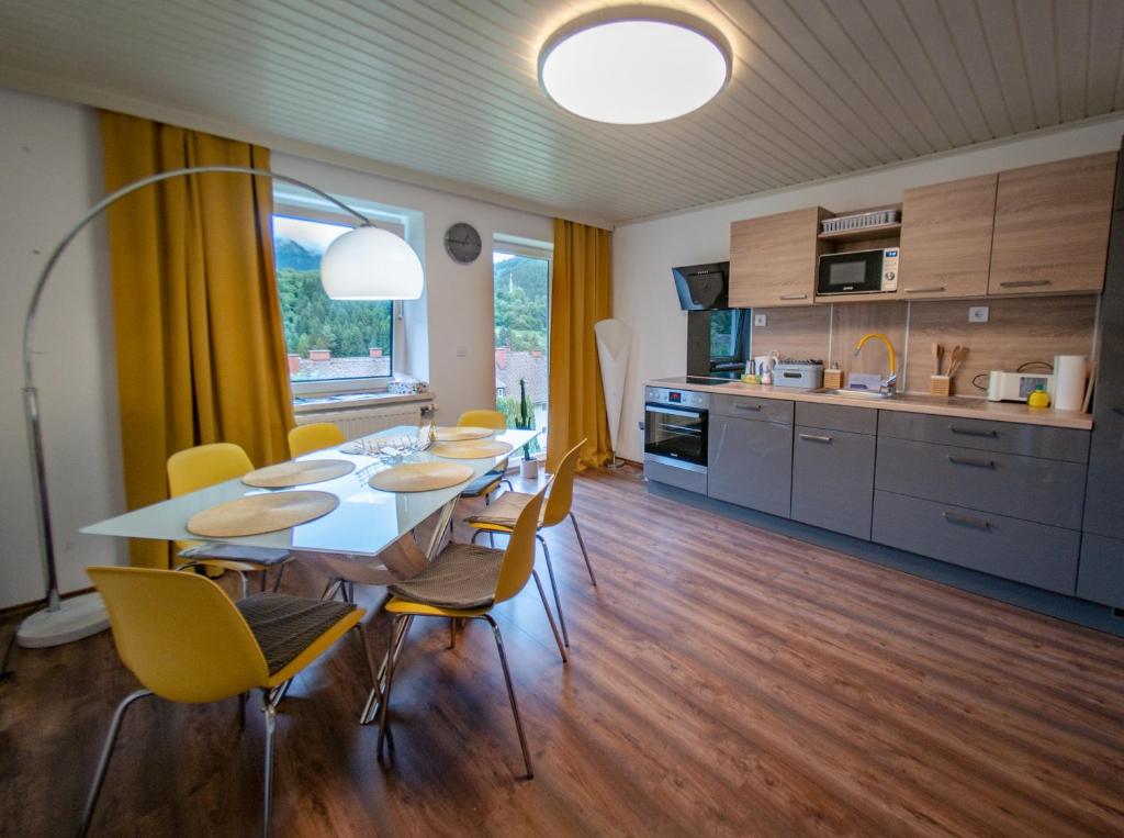 comedor con mesa y sillas en la cocina en ERZHAUS Apartments en Eisenerz