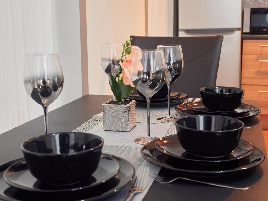 a table with wine glasses and plates on it at Cosy One Bed City Apartment -The Hub in Milton Keynes