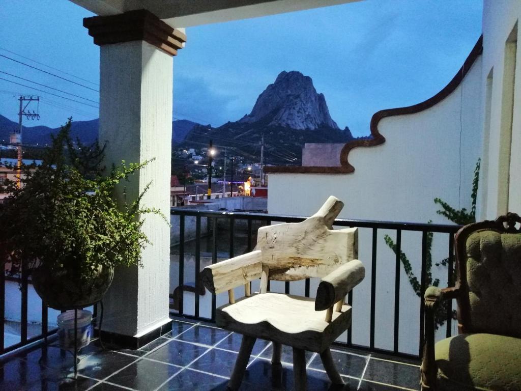 una sedia su un balcone con vista sulle montagne di Hotel Chely a Bernal